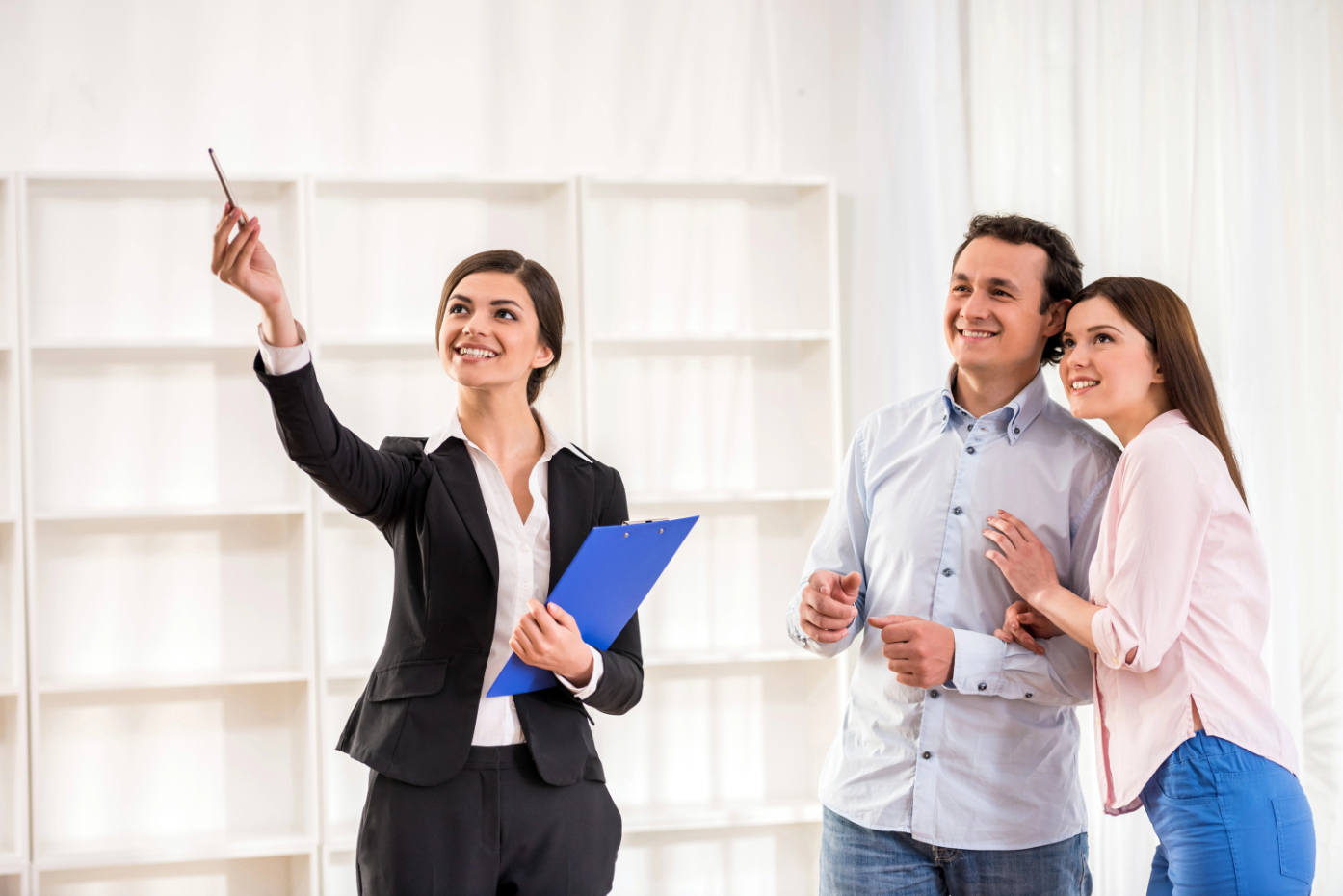 Female realtor is showing a flat to young couple